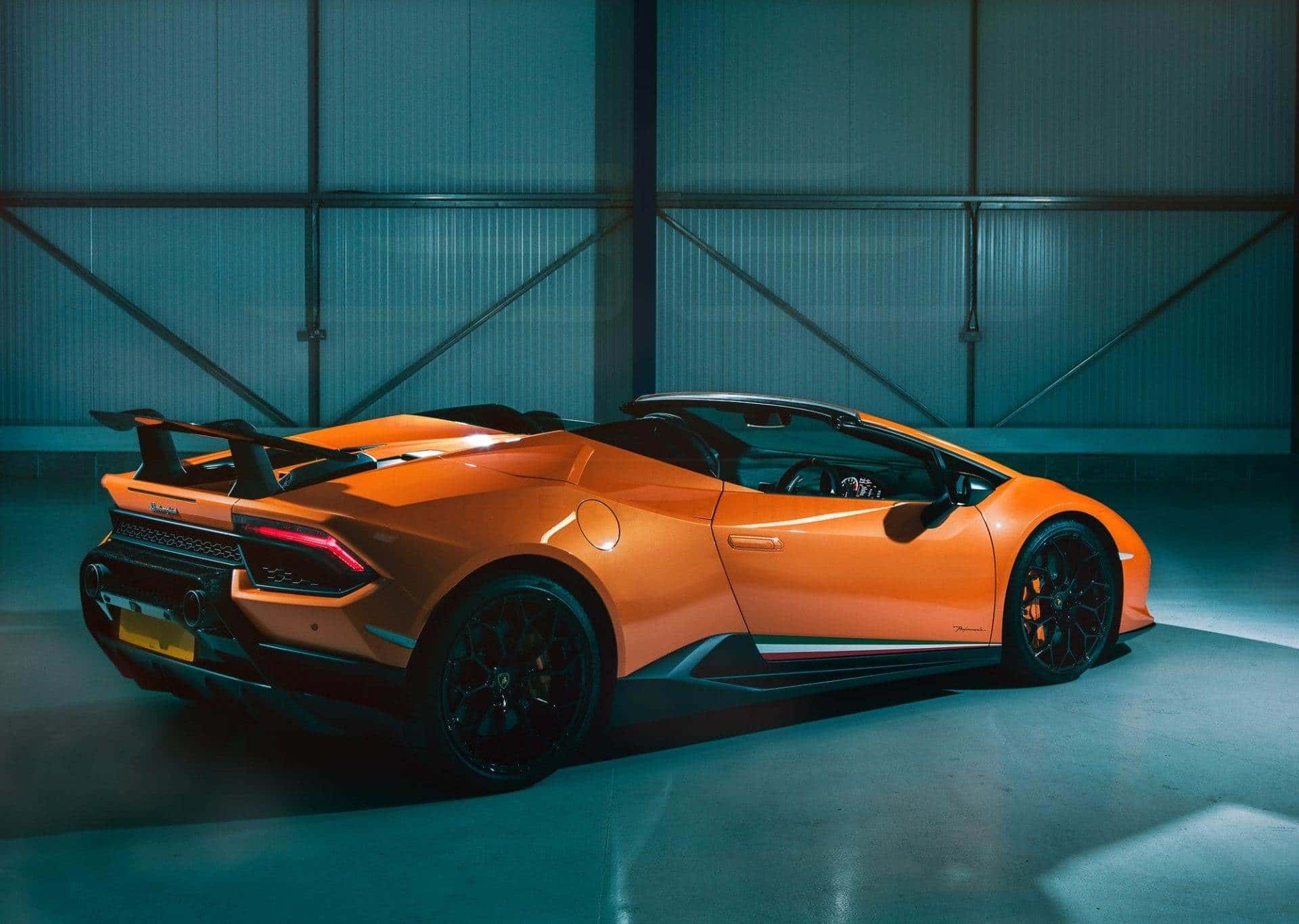 Orange Lamborghini Huracán Performante Spyder in a moody hangar